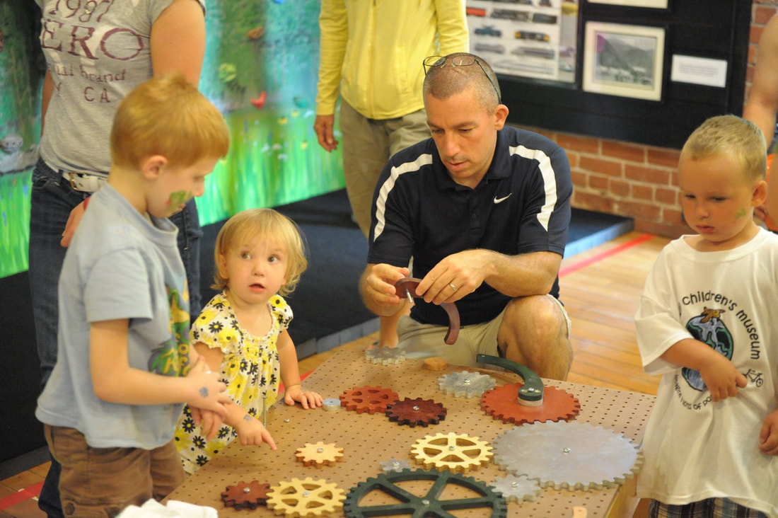 Children and a parent around a gadget table